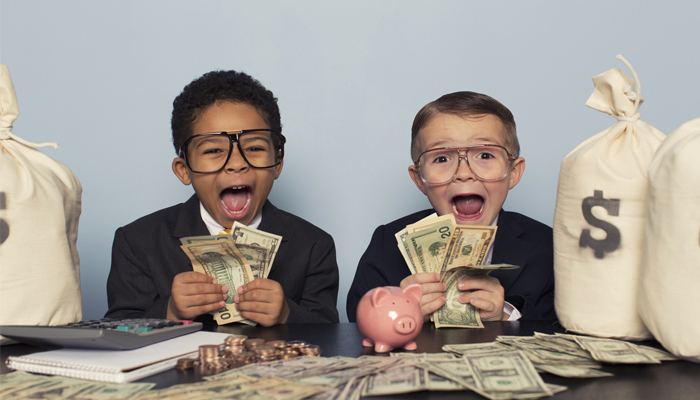 two young kids in business suits counting stacks of money from money bags