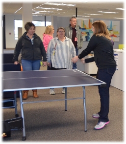 Employees playing ping pong in the employee lounge